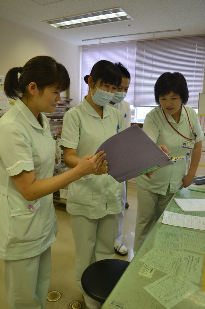 Looking at medical records, nurses discuss ways to deal with each of the patients at a hospital in Minamisoma, Fukushima Prefecture.