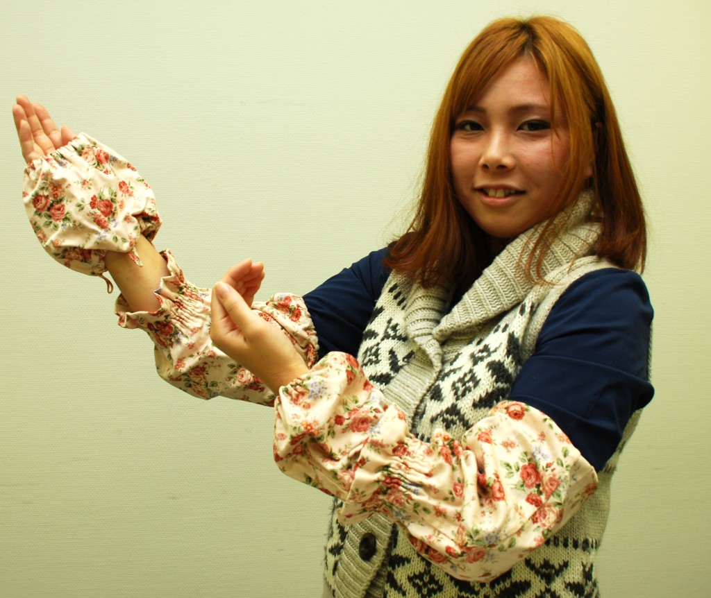 Wakana Sawadaishi shows the adjustable sleeve covers she designed at Wayo Women’s University in Ichikawa, Chiba Prefecture.