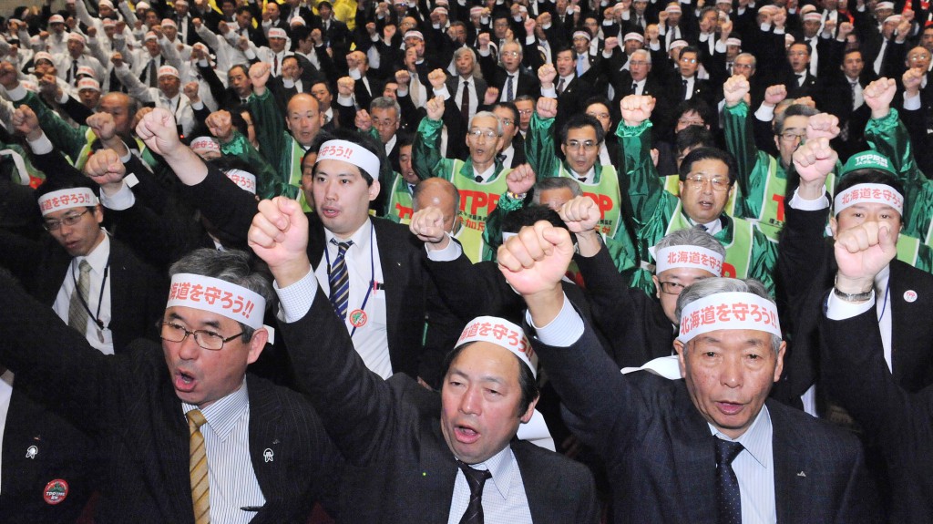 Representatives of farmers raise a shout in unison in a rally in Tokyo on Thursday, Feb. 20.
