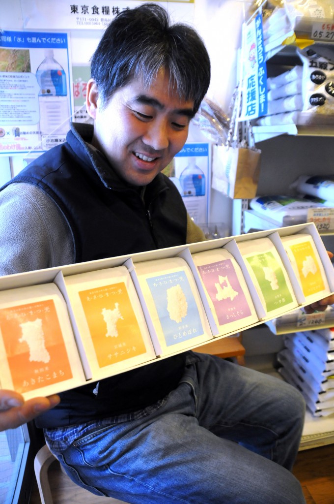 Rice shop owner Toshio Koike shows a package of six rice brands grown in the Tohoku region. 