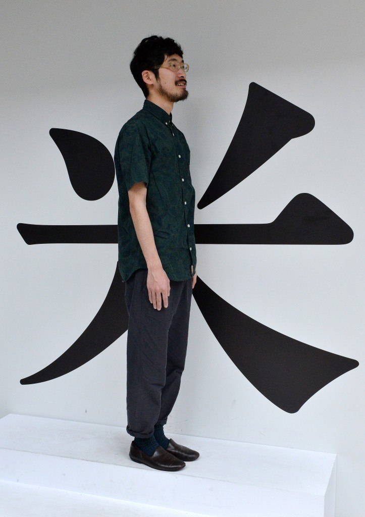 A man stands in the center of an enlarged character of “kome” (rice), an artwork titled “Come be 米(rice).” It is created to let visitors realize that they also bear the responsibility of handing down rice culture to future generations.