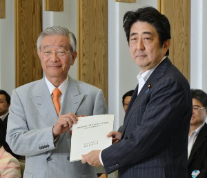 Motoyuki Oka, head of the Council for Regulatory Reform, hands a final report to Prime Minister Shinzo Abe at the prime minister’s office on Friday, June 13.
