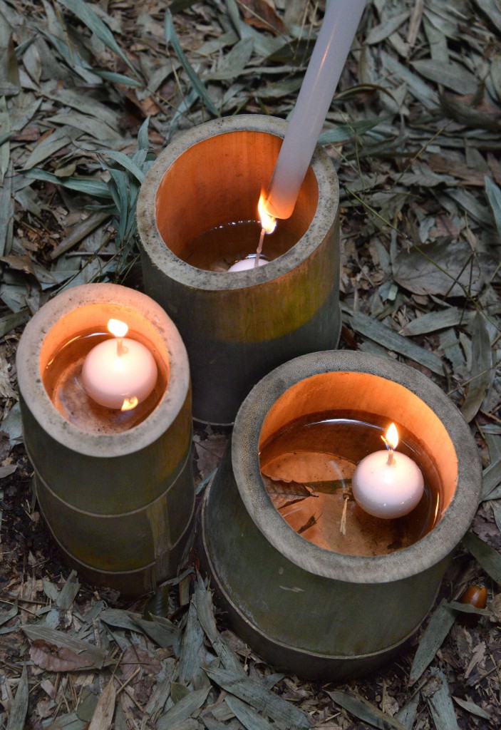 Lighting floating candles in bamboo cups.