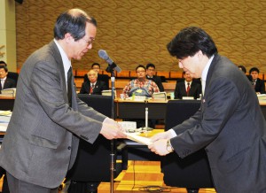 Shinichi Shogenji (left), head of the Council of Food, Agriculture and Rural Area Policies, hands a basic plan for agricultural policies to farm minister Yoshimasa Hayashi at the agriculture ministry on Tuesday, March 24.