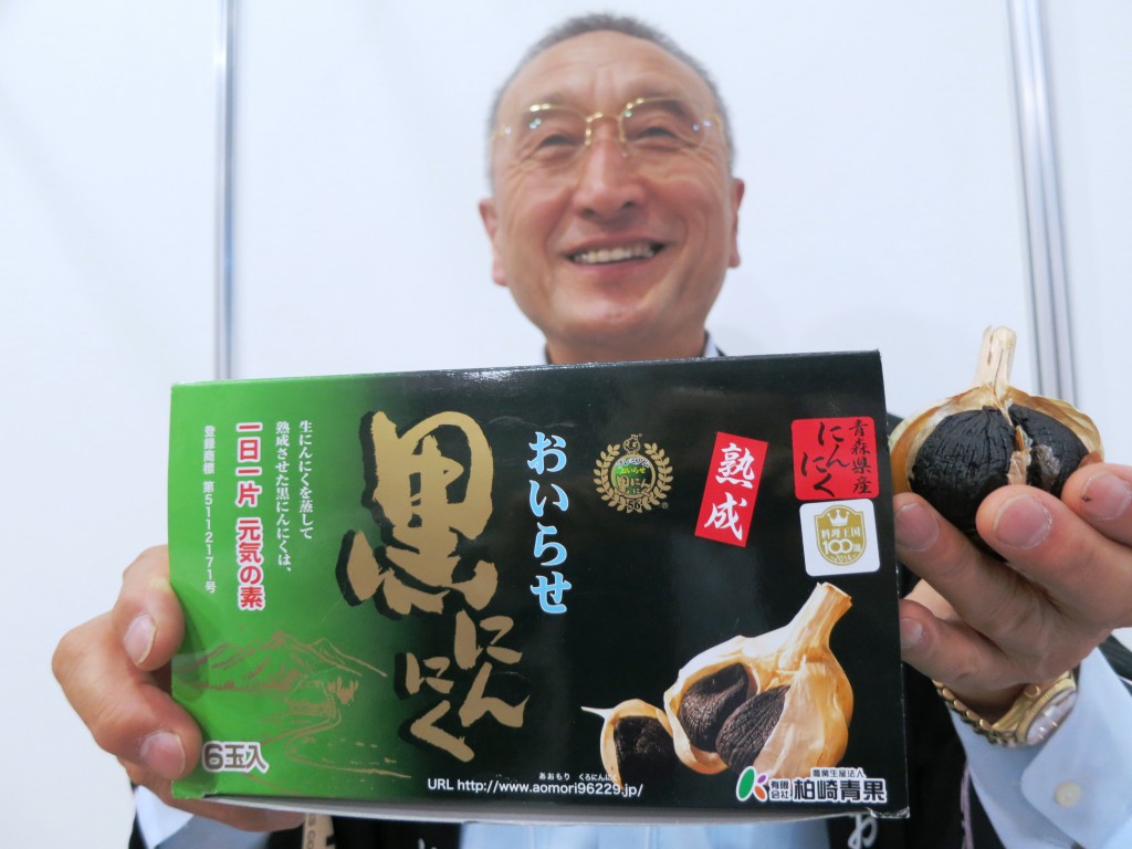 Shinichi Kashiwazaki, head of Kashiwazaki Fruit and Vegetables Corp., shows black aged garlic which the firm exports overseas.